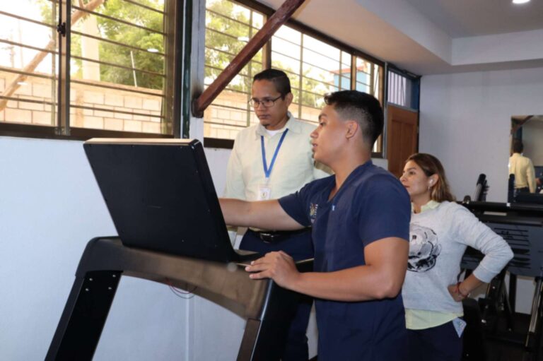 Estudiantes de Fisioterapia realizando evaluación ergonómica en el sector salud para mejorar el bienestar físico del personal.