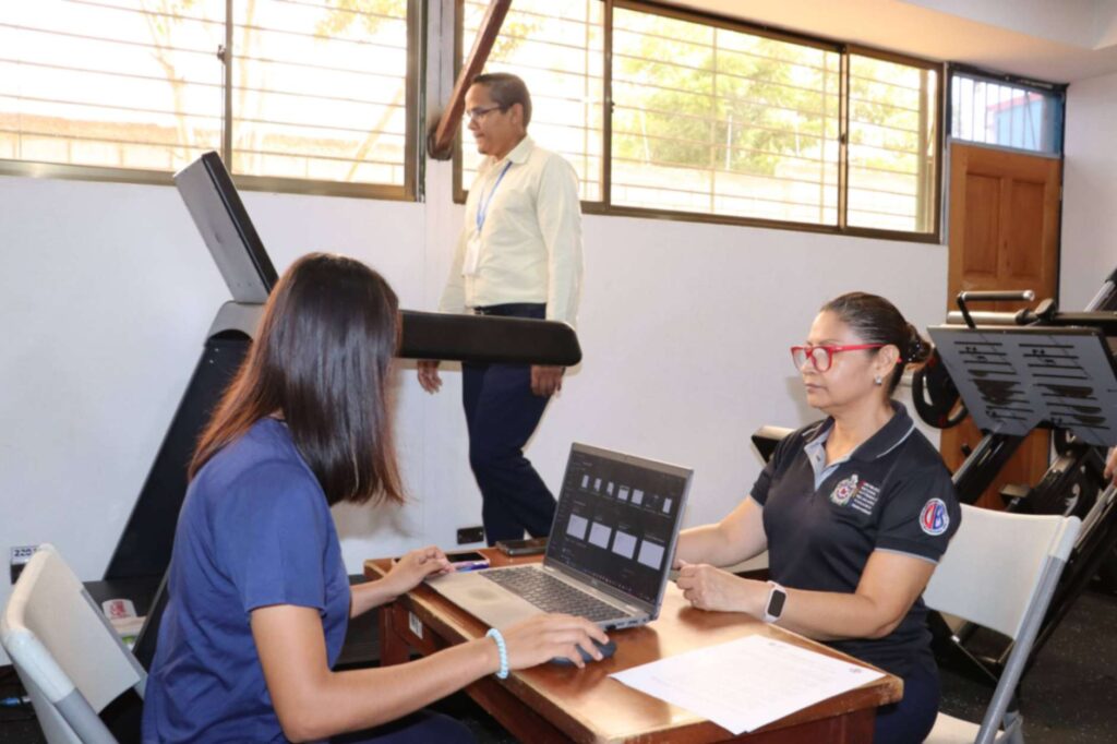 Estudiantes de Fisioterapia realizando evaluación ergonómica en el sector salud para mejorar el bienestar físico del personal.