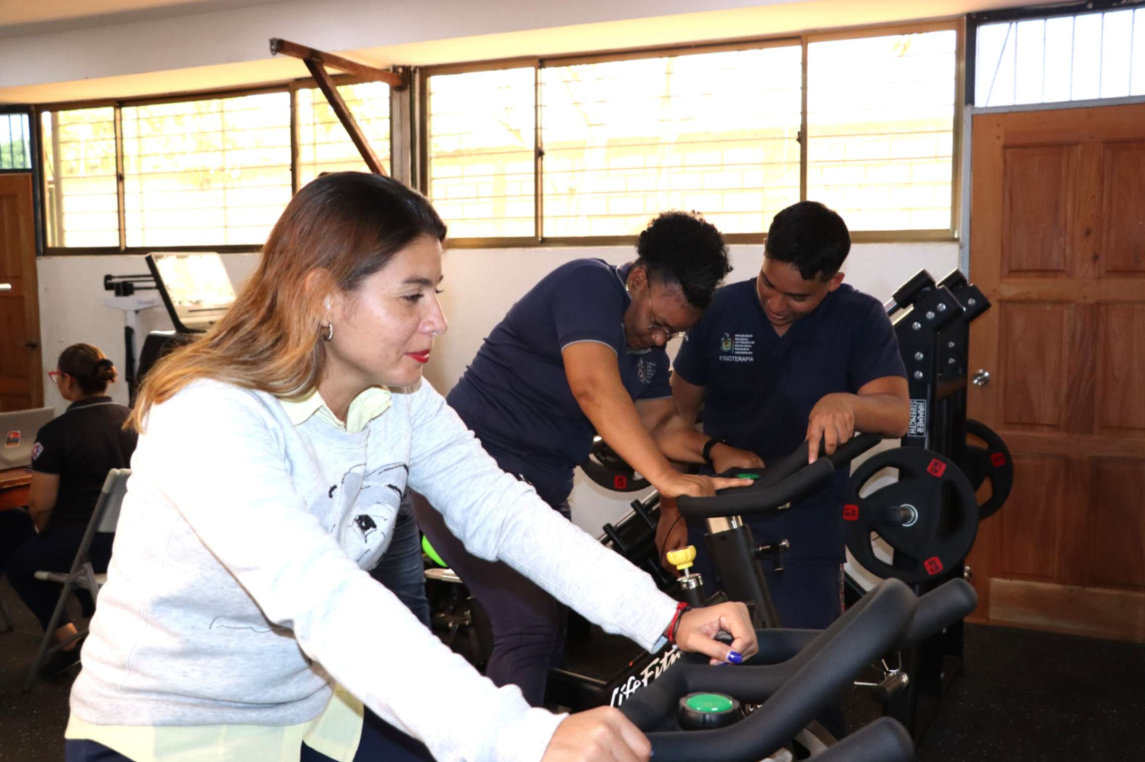 Estudiantes de Fisioterapia realizando evaluación ergonómica en el sector salud para mejorar el bienestar físico del personal.